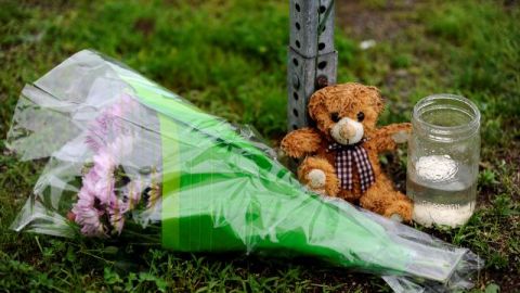 Un oso de peluche, una vela y unas flores adornan la entrada a la escuela Sandy Hook en recordación de las víctimas de la masacre.