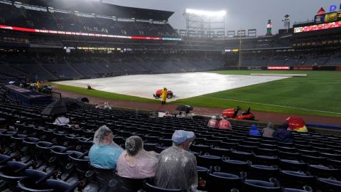 Los aficionados esperaron a que la lluvia permitiera el desarrollo del partido.