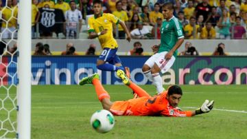 Neymar (10) remata sobre la portería de Corona ante la marcación de Carlos Salcido (3) en el cotejo que Brasil ganó 2-0.