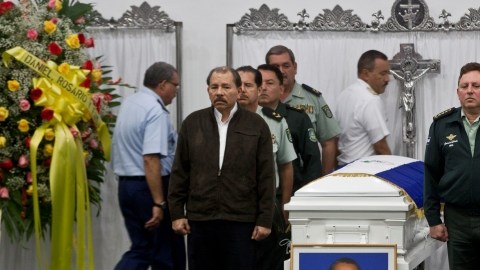 Daniel Ortega, a la izquierda, y el  jefe del Ejército, Julio César Avilés, a la derecha, de pie junto a un ataúd que contiene los restos del Coronel Mario Alberto Jiron.