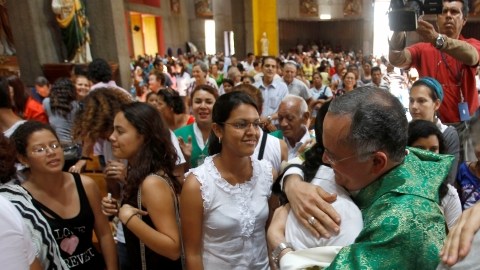 Monseñor Silvio Báez Ortega,  abraza a una mujer  después de la misa dominical en la Catedral Metropolitana de Managua, Nicaragua.