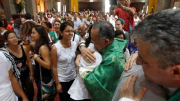Monseñor Silvio Báez Ortega,  abraza a una mujer  después de la misa dominical en la Catedral Metropolitana de Managua, Nicaragua.