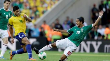 El brasileño Hulk (19) quien disputa el balón con el mexicano Gio dos Santos (10), será de la partida frente a Uruguay