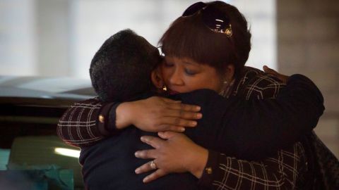 La hija de Nelson Mandela, Zindzi (der.), recibe un abrazo de una mujer no identificada, a su llega al hospital donde está internado su padre.
