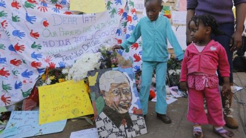 Dos niñas observan los mensajes de apoyo al expresidente sudafricano Nelson Mandela colocados a las puertas del hospital en el que permanece ingresado.
