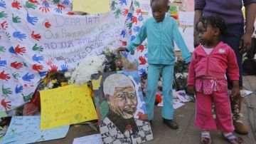 Dos niñas observan los mensajes de apoyo al expresidente sudafricano Nelson Mandela colocados a las puertas del hospital en el que permanece ingresado.