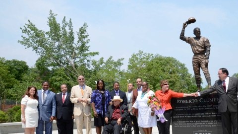 Familiares, amigos y personeros de la empresa Goya, junto a la escultora Maritza Hernández, posan alfrente del monumento al ídolo puertorriqueño.