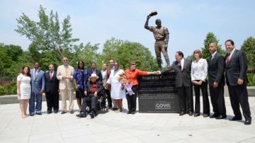 Familiares, amigos y personeros de la empresa Goya, junto a la escultora Maritza Hernández, posan alfrente del monumento al ídolo puertorriqueño.