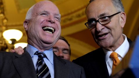 Los senadores John McCain (izq.) y Chuck Schumer luego de la votación sobre reforma migratoria, en  Washington