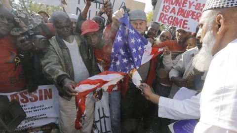 Manifestantes queman una bandera estadounidense durante las protestas.