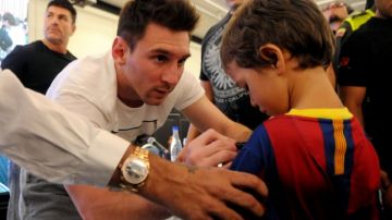 El astro del fútbol argentino Lionel Messi le firma un autógrafo a un niño colombiano, seguidor del Barcelona de España.