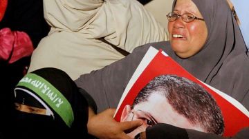 Una seguidora de Mursi llora tras el derrocamiento del mandatario, quien aparece en una foto que carga la mujer.