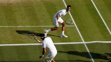 El serbio Novak Djokovic (de frente),  venció al argentino Juan Martin Del Potro en cinco sets para avanzar a la final de Wimbledon.