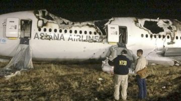 Varios investigadores en la escena del accidente del vuelo 214 de Asiana que se estrelló al aterrizar en el Aeropuerto Internacional de San Francisco.