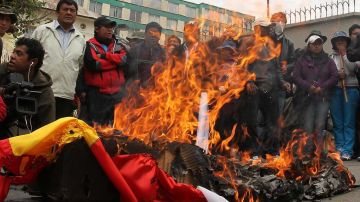 Seguidores del presidente de Bolivia, Evo Morales, queman las banderas de España y Portugal ante la embajada de EE.UU. de La Paz.
