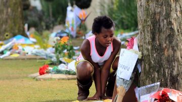 La joven Katlego Matswalela lee algunos de los mensajes que han dejados los simpatizantes de Nelson Mandela en las afueras de su casa en Johannesburgo.