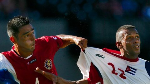 Michael Umana, de Costa Rica, y Yoandir Puga, de Cuba, disputan el esférico