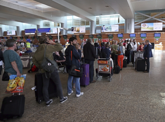 Un grupo de pasajeros esperan para chequear  su equipaje en un vuelo con destino a La Habana en el aeropuerto de Sheremetyevo en Moscú.