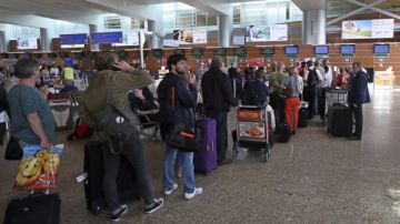 Un grupo de pasajeros esperan para chequear  su equipaje en un vuelo con destino a La Habana en el aeropuerto de Sheremetyevo en Moscú.