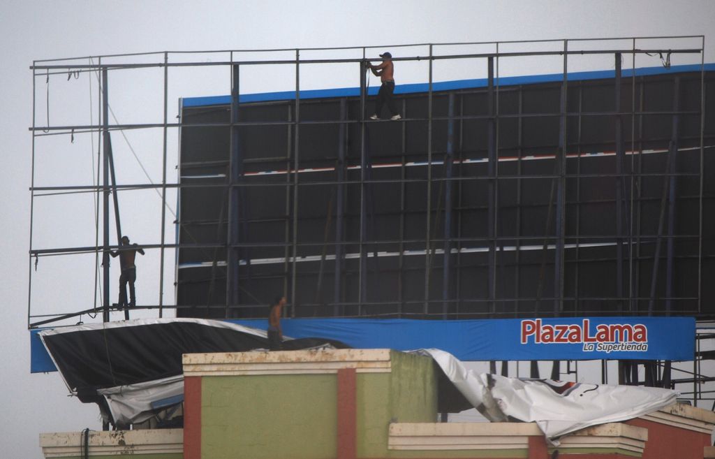 Trabajadores en Santo Domingo desmantelaron el martes una valla publicitaria gigante, como parte de los preparativos ante la llegada de la tormenta tropical Chantal a República Dominicana.