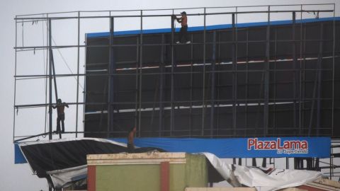 Trabajadores en Santo Domingo desmantelaron el martes una valla publicitaria gigante, como parte de los preparativos ante la llegada de la tormenta tropical Chantal a República Dominicana.