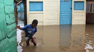 Un niño camina por una calle inundada en Santo Domingo.