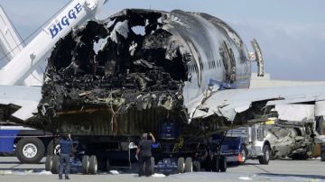 Dos hombres toman fotos de la parte posterior del avión de Aerolíneas Asiana,  accidentado el sábado pasado  cuando intentaba aterrizar en el aeropuerto de San Francisco .