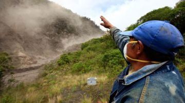 Un habitante señala el lugar por donde descendieron 'flujos piroclásticos' (avalanchas de rocas candentes) tras la fuerte explosión registrada en el volcán Tungurahua ayer. Varias personas fueron evacuadas por las autoridades.