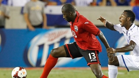 Cornell Glen (13) es acosado por el hondureño  David Velásquez (5), quien vio la tarjeta roja en el primer tiempo.