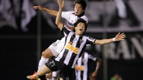 Wilson Pittoni, de Olimpia, disputa el esférico con Luan, de Atlético Mineiro