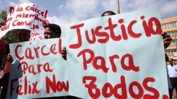 Un grupo de manifestantes con pancartas protestan frente a la sede de la Corte Suprema de Justicia y del Congreso Nacional en Santo Domingo.