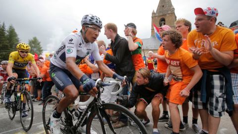 Quintana avanza entre la gente que lo apoyó a su paso, el líder Froome sube detrás de él.