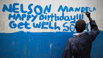 Un niño escribe  un mensaje de felicitación  al expresidente sudafricano Nelson Mandela, ayer,  en la escuela de primaria Kilimani de Nairobi, Kenia.