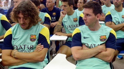 Lionel Messi (der.) y Carles Puyol (izq.) escuchan a su presidente hablar sobre la salida de Tito Vilanova en el Centro Joan Gamper.