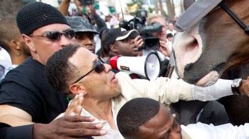Activista de Houston Quanell X, centro, y otros son empujados hacia atrás por la policía.