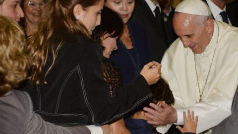 La mandataria de Brasil, Dilma Rousseff (centro), observa al papa Francisco (derecha) saludando a un niño en el Palacio Guanabara, sede del gobierno de Río de Janeiro.
