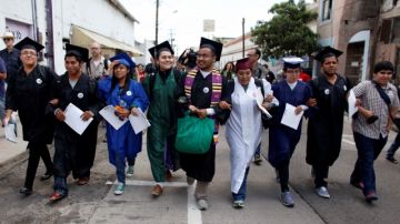 Grupo de 'Dreamers' vistiendo su capas y birretes de graduación intentaron ayer cruzar a EEUU, pero fueron detenidos.