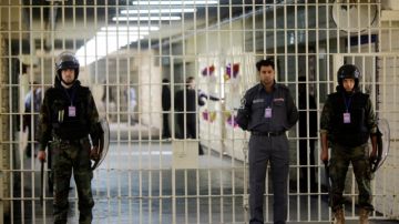 Guardias  vigilan las celdas en la prisión de Abu Ghraib donde un  Intento de fuga dejó  al menos 25 miembros de las fuerzas de seguridad iraquíes muertos.