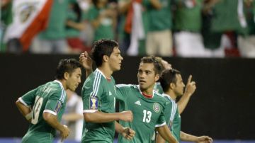 Raúl Jiménez es felicitado por sus compañeros tras convertir el gol del triunfo de México 1-0 ante  Trinidad y Tobago.