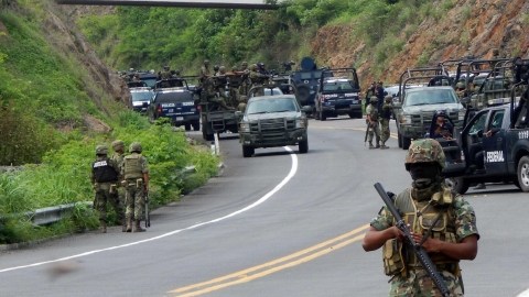 Agentes federales y soldados del Ejército mexicano resguardan una carretera  en el municipio de Arteaga, en el estado mexicano de Michoacán.