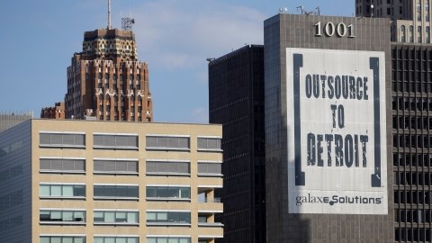 Un letrero de  'Outsource to Detroit' de  Galaxe.Solutions es desplegado en un edificio de Detroit.