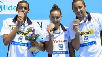 De izq. a der. los nadadores de Brasil Allan Do Carmo, Poliana Okimoto y Samuel De Bona, muestran la medalla de bronce conseguida en la final de los 5km en aguas abiertas en desarrollo del Mundial de natación en Barcelona.