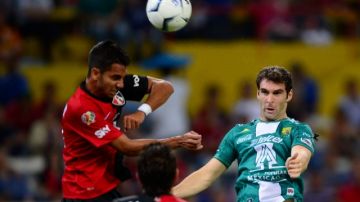 Mauro Boselli, autor del primer gol del León, intenta rematar de cabeza ante dos defensores rojinegros.