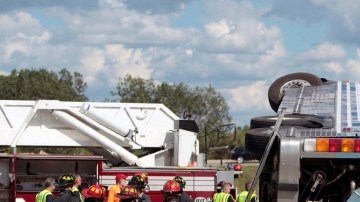 Bomberos trabajan para auxiliar a los pasajeros del autobús que se accidentó en Indianápolis, Indiana, ayer.