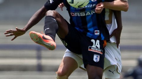 Wilberto Cosme trata de controlar el balón ante la presión de Marco Palacios en el Estadio Olímpico Universitario, en la fecha 2.