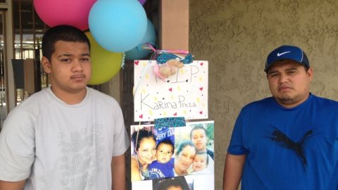 Carlos Cerna (Izq.) con su hijo, Carlos Jr., de 14 años. junto al altar donde murió su esposa, Karina Preza.