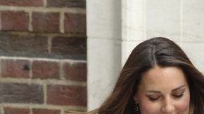 El príncipe Guillermo, duque de Cambridge (derecha), y su esposa, Catalina, sostienen a su bebé.