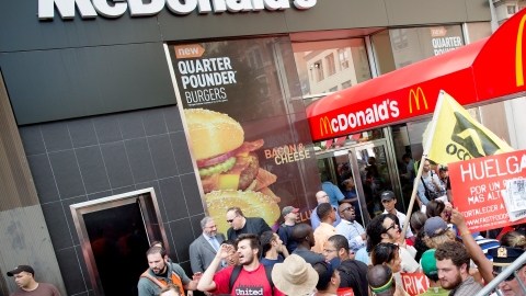 Manifestantes apoyan a los trabajdores de comida rápida afuera de un McDonald's en NY para demandar mejores salarios.