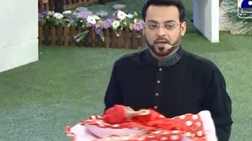 El presentador Aamir Liaquat Husein con uno de los bebés que dio en adopción a una pareja que participaba en su programa de TV.