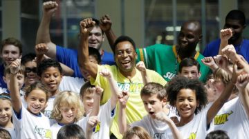 El astro brasileño Pelé posa con un grupo de niños que asistió ayer a una clínica de fútbol en Manhattan.
